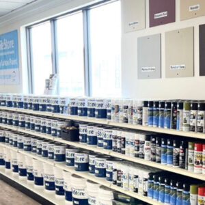 Paint cans and spray paint on shelves in ReStore stores.