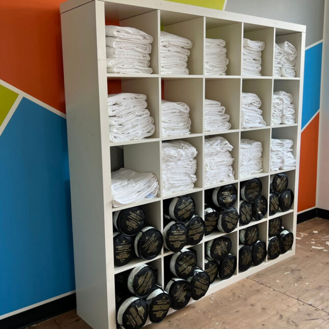 White towels and black blankets on shelves.