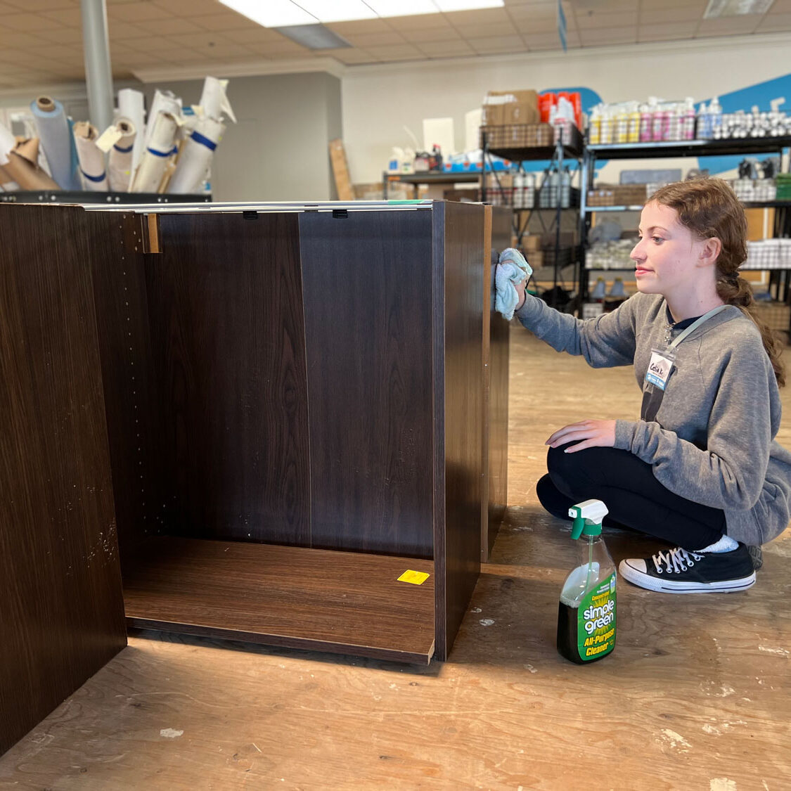 Young lady volunteer polishing a table.