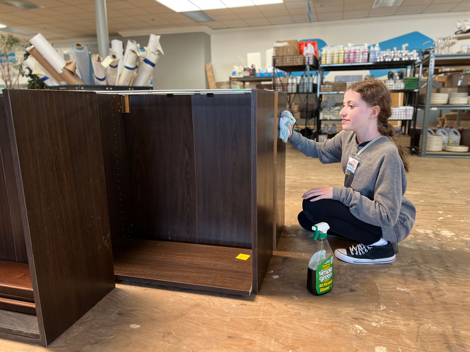 Young lady volunteer polishing a table.