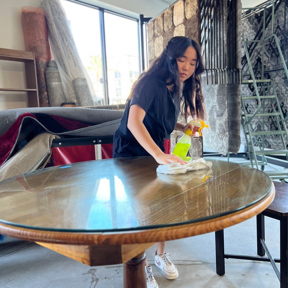 Young lady polishing a table.