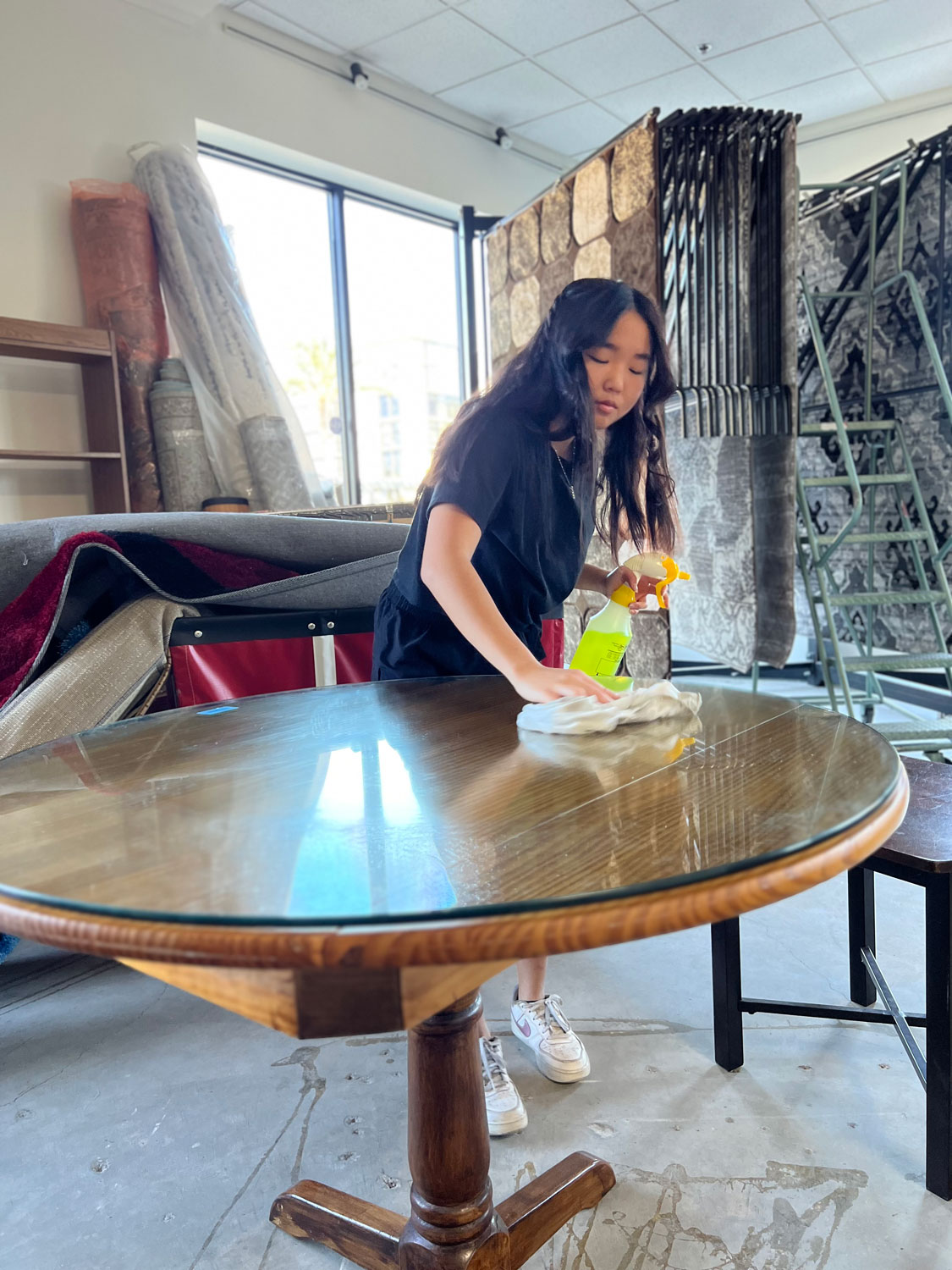 Young lady polishing a table.