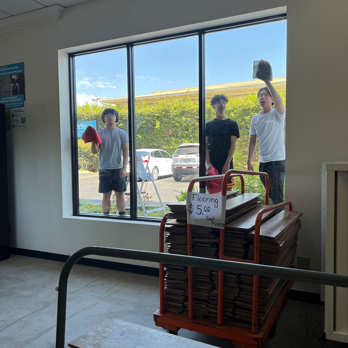 Young men volunteers cleaning window of the Resore.