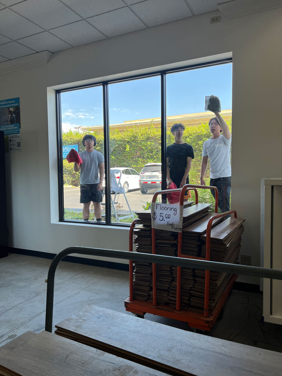 Young men volunteers cleaning window of the Resore.