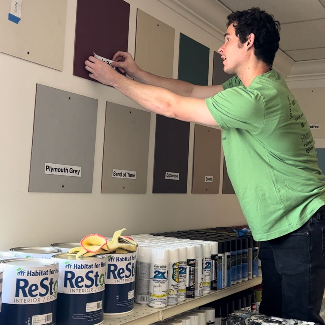 Young man labeling paint tiles on the wall.