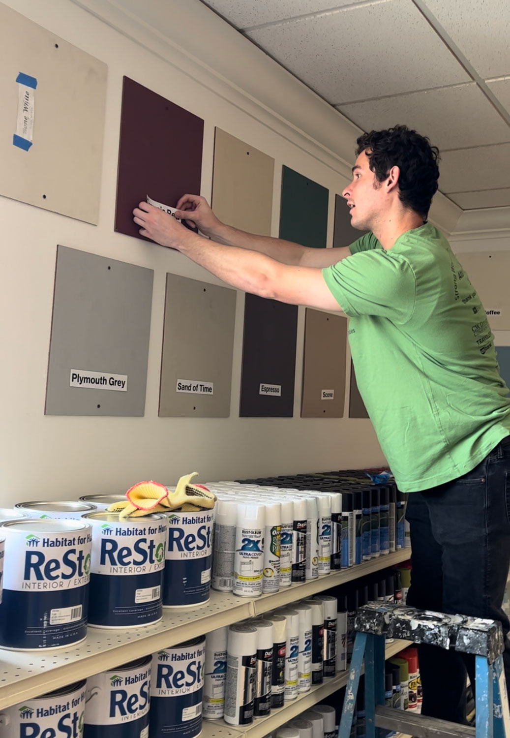 Young man labeling paint tiles on the wall.