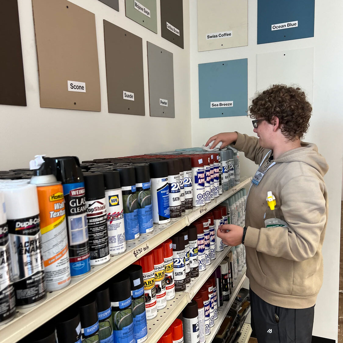 Young man organizing the paint shelves.