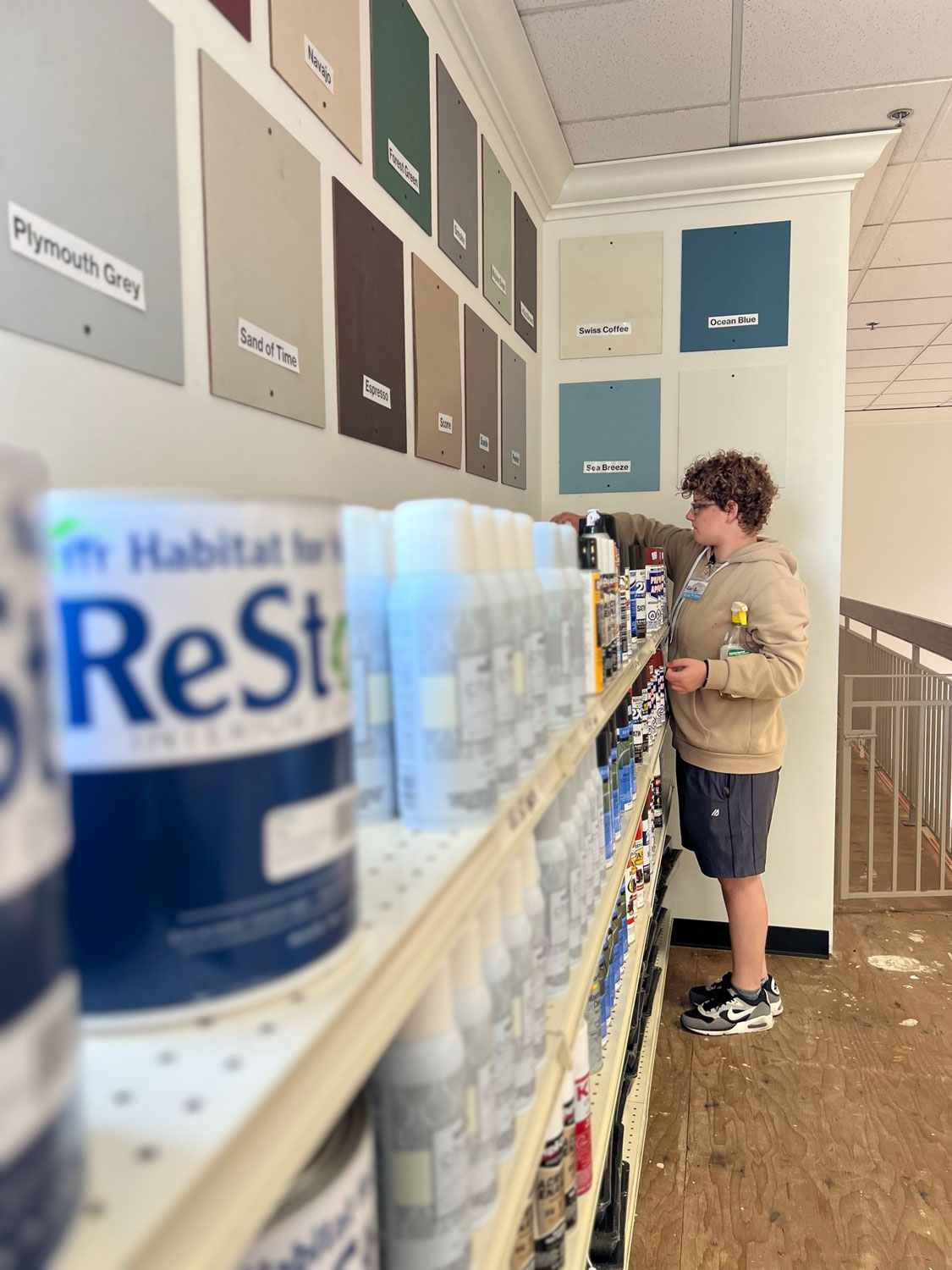 Young man cleaning the paint shelves.