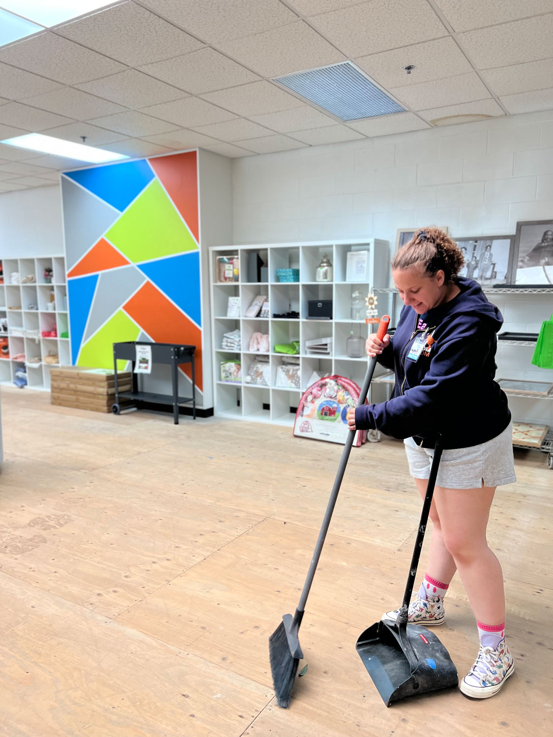 Young lady volunteer sweeping the floor.